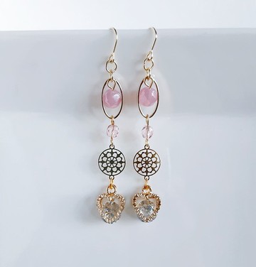 內含鋯石的愛心墜飾隨之搖曳，搭配俐落的橢圓圈與溫柔的桃花粉色長耳環。時尚、禮物、可更換為低過敏性耳針或耳夾。