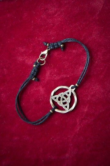 Triquetra標志 青銅和棉繩手鏈。 三重結形式的異教珠寶。