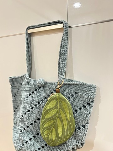 淺綠色柔軟絨布上繡有葉子圖案的迷你零錢包。