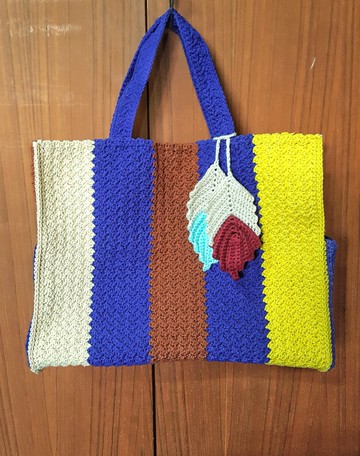 可肩背或手提的編織包，適合上班使用。