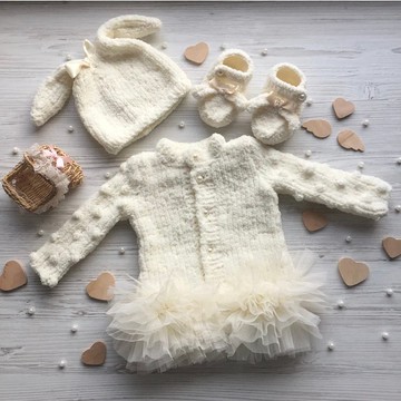 為女嬰針織象牙色衣服。連衣裙、兔子帽和兔子靴。