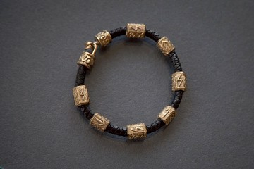 黑色皮革繩上的手鏈, 帶有符文。 維京風格的珠寶。男士手鏈