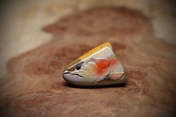 A handcrafted wooden golden trout brooch