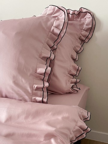 帶有荷葉邊的 pink 枕頭套，配有黑色滾邊，100% 純棉緞面