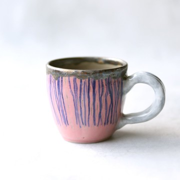 粉紅背景上有藍色垂直條紋的小咖啡杯