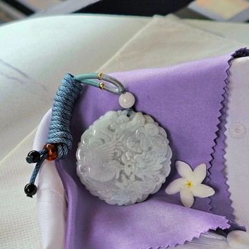 龍鳳呈祥翡翠墜飾，淡雅白綠色澤，質地溫潤，雕工精緻，圓形墜飾，寬度4.65公分。