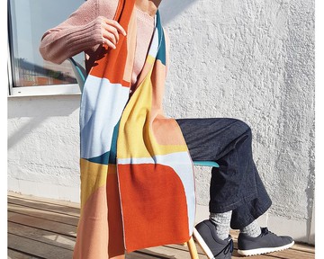 玩玫瑰色和綠色圍巾。她的圍巾由純美利奴羊毛製成。